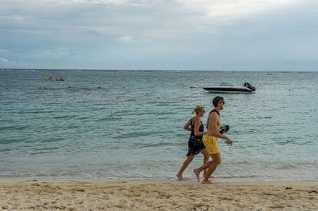 Man and woman walking on the beachのeditorial素材