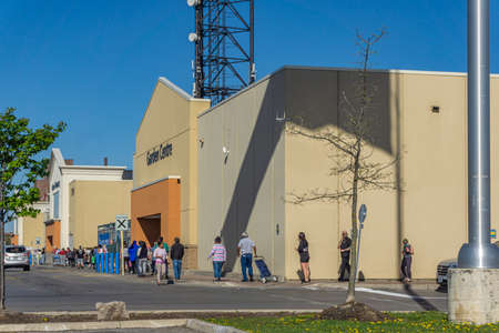 Long line of customers waiting to get in the superstore during covid 19 pandemic
