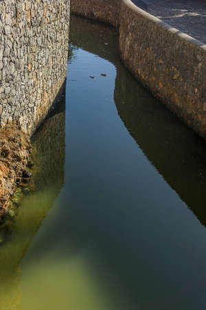 Vertical shot of a water canal of stone construction