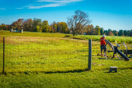 Man charging a cannon to shoot pumpkins on a farm for halloween seasonのeditorial素材