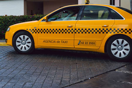 Yellow taxi car stationary at the entrance of a buildingのeditorial素材