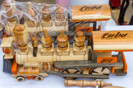 Small historical train car models carved from wood displayed at a tourist souvenir shop in Cubaのeditorial素材