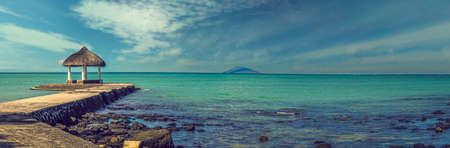 Pier with a beach kiosk overlooking a beautiful lagoon of turquoise seaの写真素材