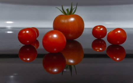 Red tomatoes on reflective surfaceの写真素材