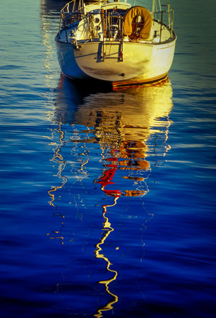 Boat reflected on blue lake waterの写真素材
