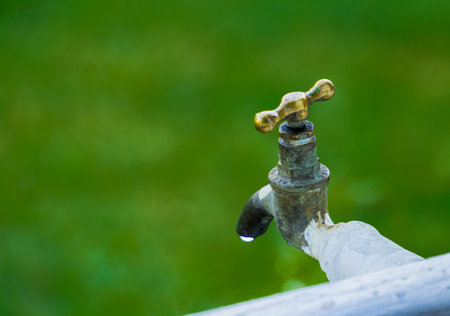 Water tap outdoor with a drop of water coming outの写真素材