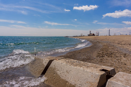 Concrete breakwater on sunny beach coastの写真素材