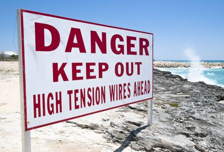 The warning sign on Grand Bahama Island rocky beach の写真素材
