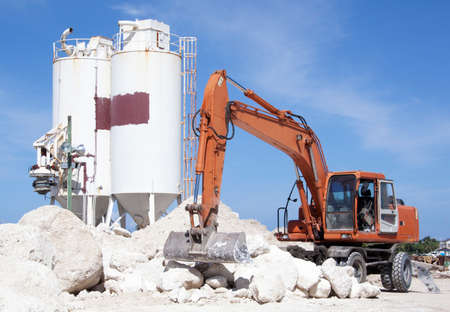 The excavator next to big stones, the industrial view in Nassau (The Bahamas).