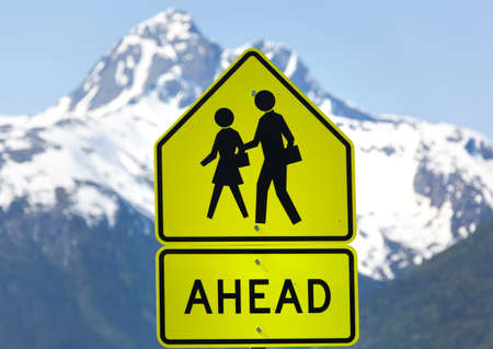 The warning sign about people ahead on Skagway town street.の写真素材