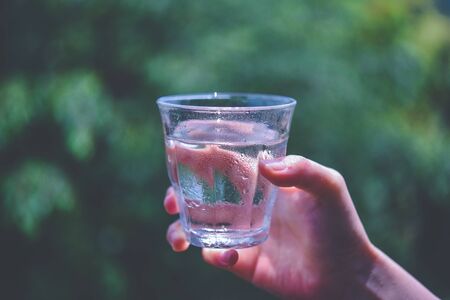 a woman's hand with a glass of waterの写真素材