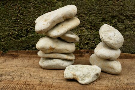 Balancing Stones on a wooden board against the old plaster                              の写真素材
