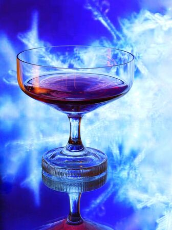 Glass of Cognac isolated on blue background                              の写真素材