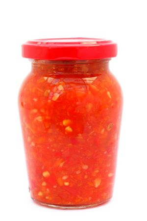 Caucasian sauce adjika in a glass jar is isolated on a white background の写真素材