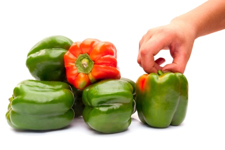 Green peppers and hand teenager isolated on white backgroundの写真素材