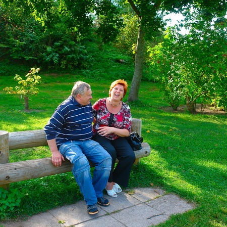 Happy elderly couple talking in the parkの写真素材