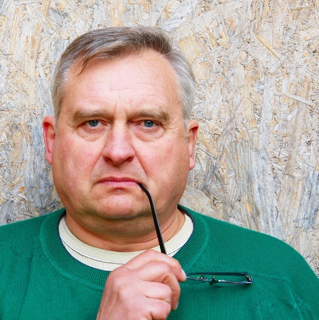 Portrait of elderly man in the background of the building slabの写真素材