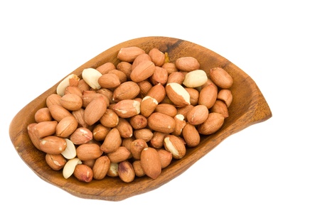 A pile of roasted peanuts in a wooden bowl on a white background