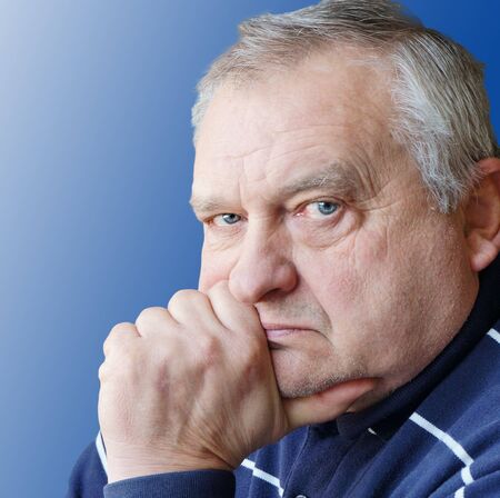 Portrait of the elderly man on a blue background.の写真素材