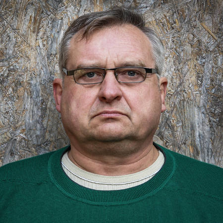 Elderly man with glasses and green sweater