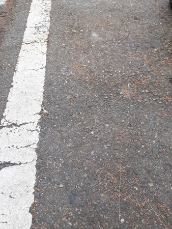 White line on the asphalt road in the city, closeup of photoの写真素材