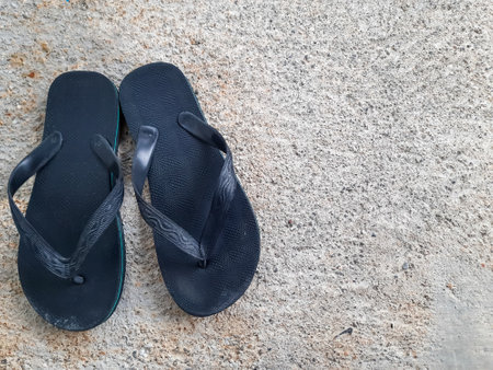 Black flip flops on cement floor. Top view with copy space.の写真素材
