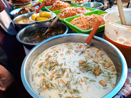 A variety of traditional Indonesian street food dishes served in large trays at a local market in Sicincin, West Sumatraの写真素材