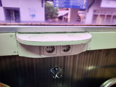 Shelf for placing items such as drinks, food, or phones and a power outlet for charging electronic devices inside an Indonesian train cabinの写真素材