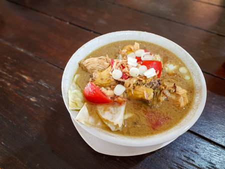 Chicken tongseng served in a white bowl with vegetables and tomato. Traditional Indonesian food from Java, often found in Javanese restaurantsの写真素材