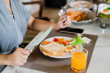 Closeup on a young woman she is having breakfast.の写真素材