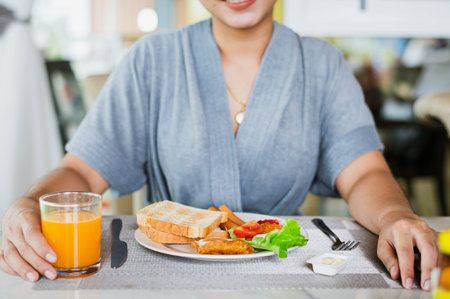 Closeup on a young woman she is having breakfast.の写真素材