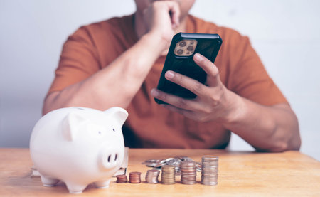 Man hand holding phone and thinking for saving money concept. Financial business investment,...