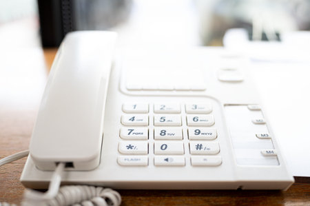 Close up of telephone devices on desk for customer service support. Call center concept.の写真素材