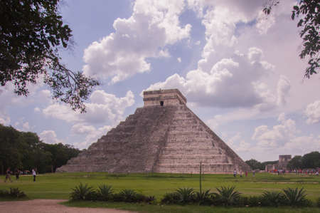 Mayan structures in Chichen Itza where you can see the pyramid and some symbols, this on a sunny day with some cloudsの写真素材