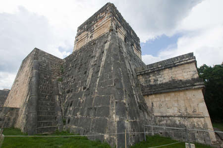 Mayan structures in Chichen Itza where you can see the pyramid and some symbols, this on a sunny day with some cloudsの写真素材