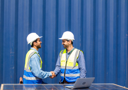 Two engineers team discuss plan using photovoltaic solar panel at workplace, sustainable development conceptの写真素材