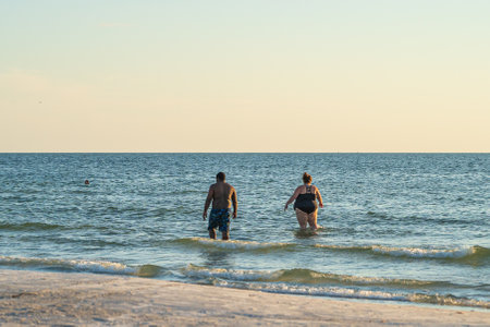 vacationing diverse couple standing in water on Florida beachのeditorial素材