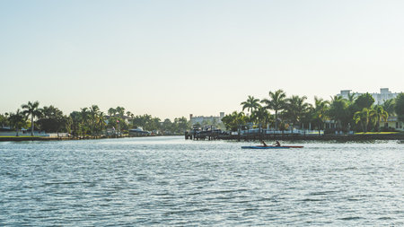 Two People Kayaking on intercoastal waterway against palm trees and clear skyのeditorial素材