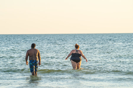 vacationing diverse couple standing in water on Florida beachのeditorial素材