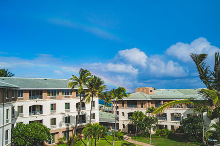 Double rainbow in blue sky above resort grounds in tropical paradiseのeditorial素材