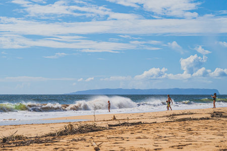 Tourists play in the large crashing surf of pacific ocean in Hawaiiのeditorial素材