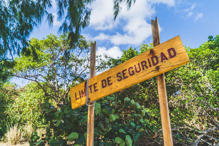Warning sign at edge of beach against blue skyの写真素材