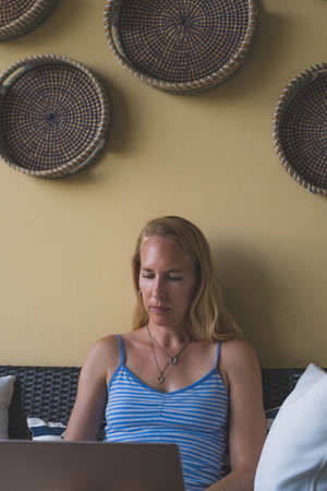 Concentrating Woman working on laptop in casual clothes, freelance sittingの写真素材