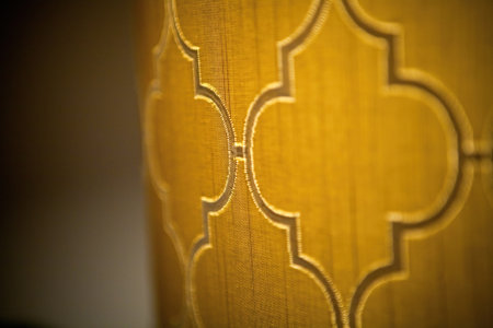 Closeup shot of decorated brown painted shapes with a pattern on a yellow wall backgroundの写真素材