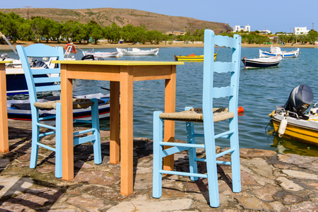 Milos island, Greece - MAY 27: Traditional Greek taverna on the seafront on the beach - bright chairs and table in MAY 27, 2015, Milos island, Cyclades, Greece.のeditorial素材