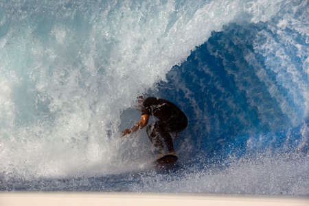 Surfer surfing on artificial waveの写真素材