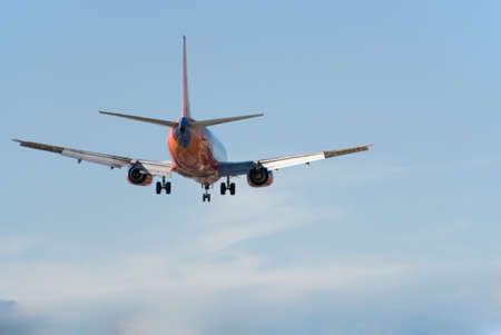 Passenger Jet coming in for a landing against blue sky.
