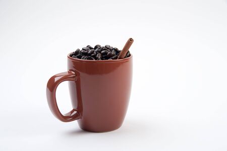 Brown coffee mug filled with coffee beansの写真素材