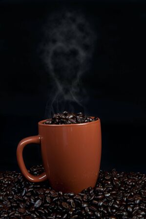 cup of coffee beans with cup on top of coffee beans with steam coming up in the shape of a heartの写真素材