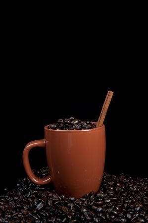 Coffee mug with coffee beans and cinnamon stickの写真素材